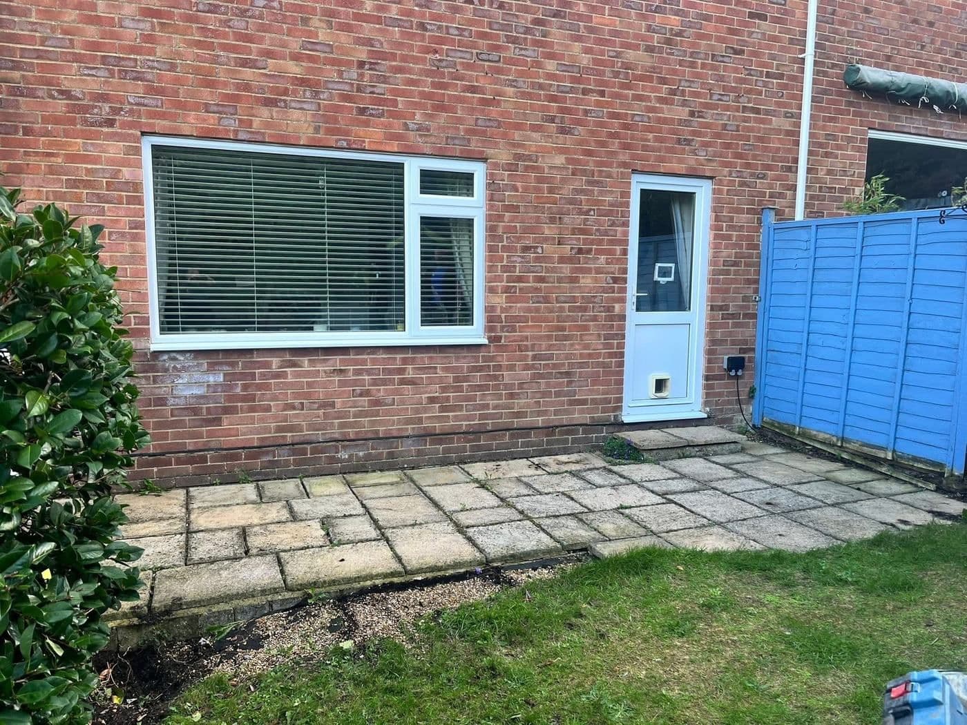 Before: a rear garden patio of old, uneven concrete slabs